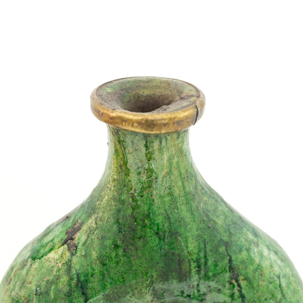 Close-up of a Tamegroute pottery green ceramic vase with a cracked golden rim, showcasing its textured surface and narrow neck against a plain white background.