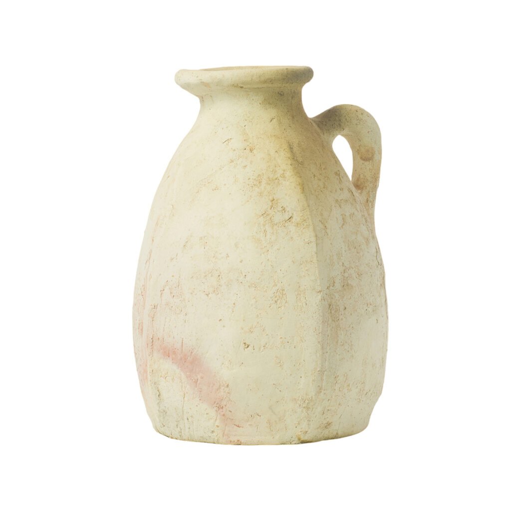 A weathered, cream-colored clay jug with a single handle and a narrow neck, reminiscent of Tamegroute pottery.