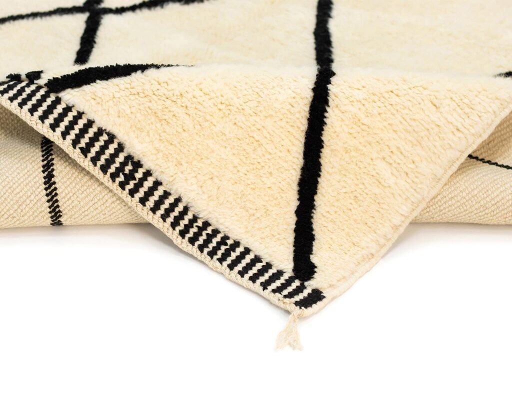 A close-up of a meticulously crafted piece featuring black crisscross lines and a corner with striped edging. This exquisite item exemplifies handmade home decor, adding a touch of elegance to any space.