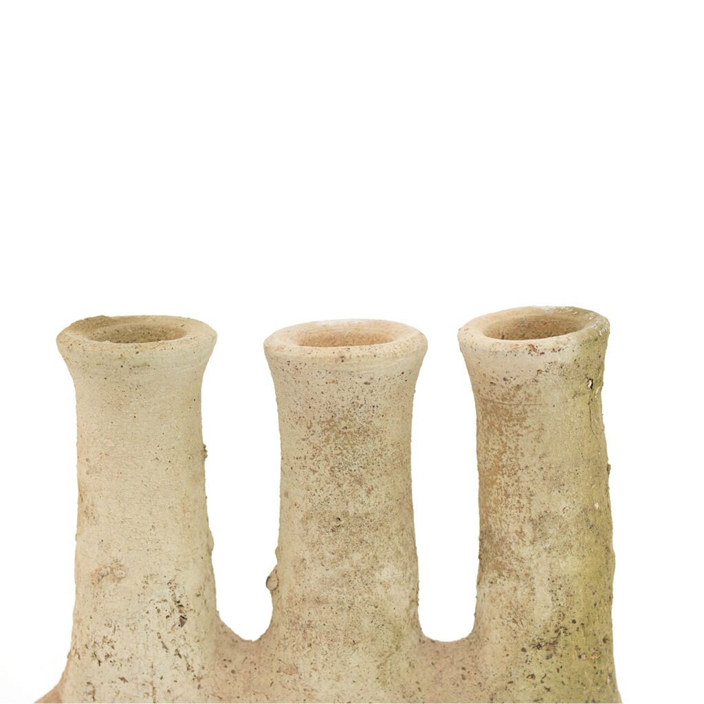 A textured, unglazed Tamegroute pottery vase in beige features three vertical, tube-like openings, set elegantly against a plain white background.