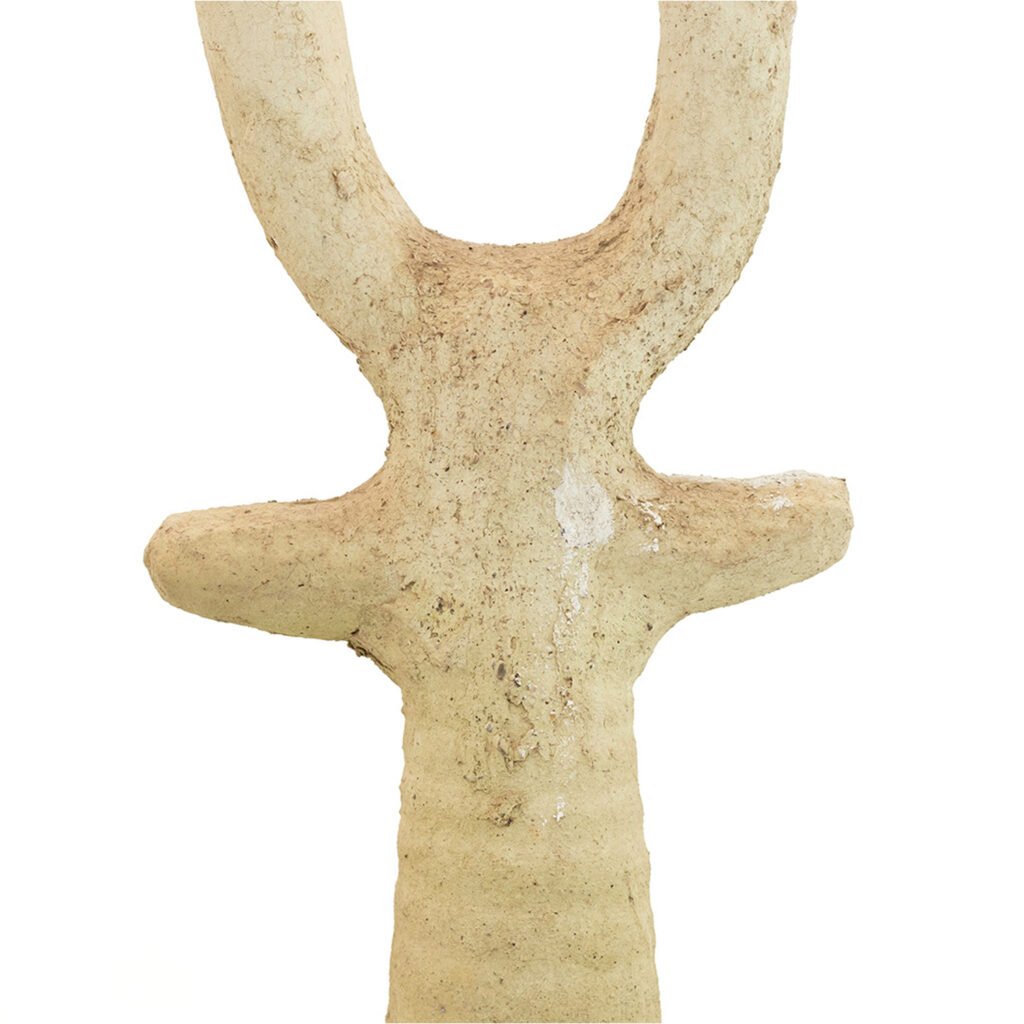 A beige, textured sculpture reminiscent of unglazed Tamegroute pottery showcases a U-shape on top and two horizontal protrusions below, against a plain white background.