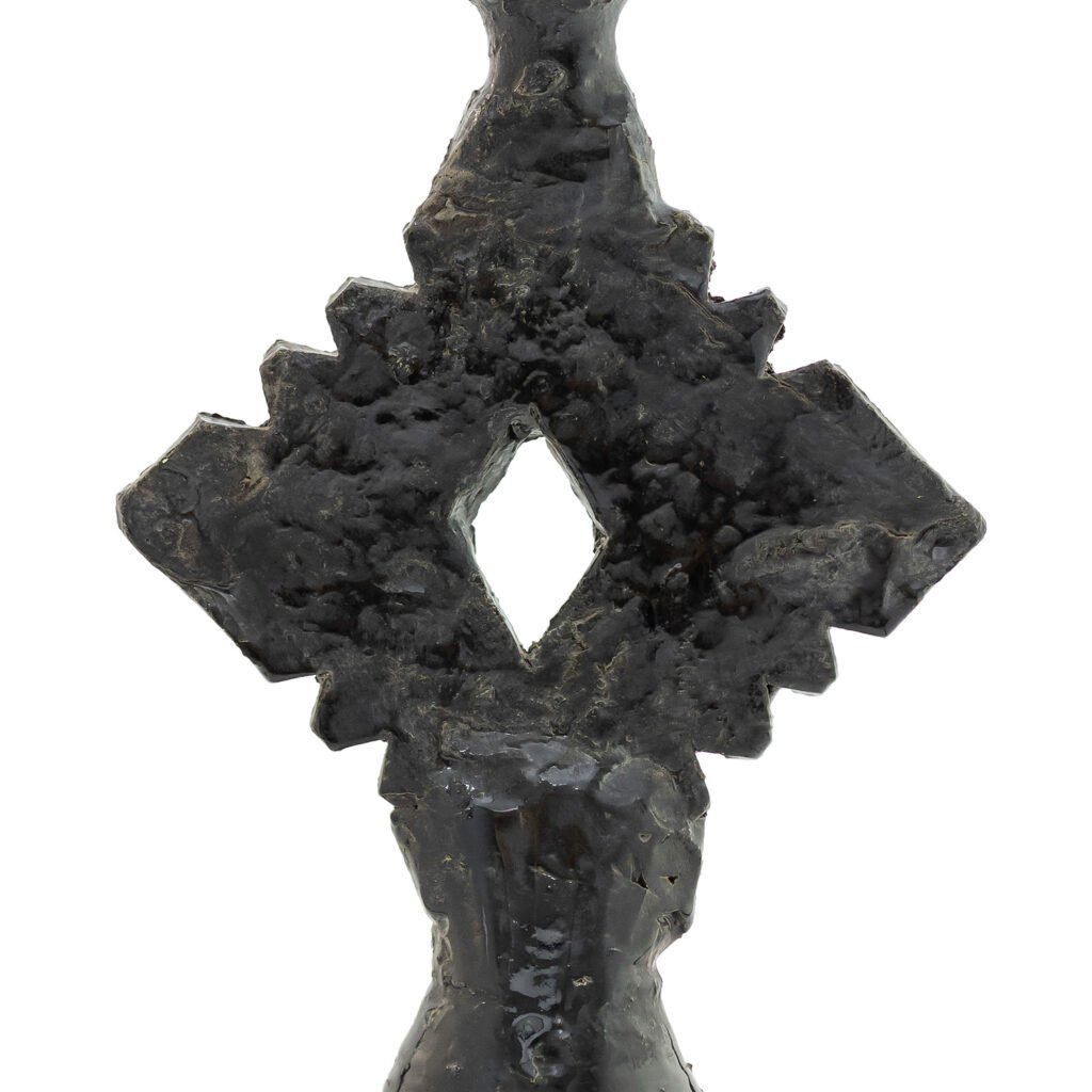 The piece evokes the mystique of Tamegroute pottery, with a textured, abstract form featuring a diamond-shaped cutout. Its uneven, dark surface captures an earthy allure reminiscent of the famed Moroccan craft.