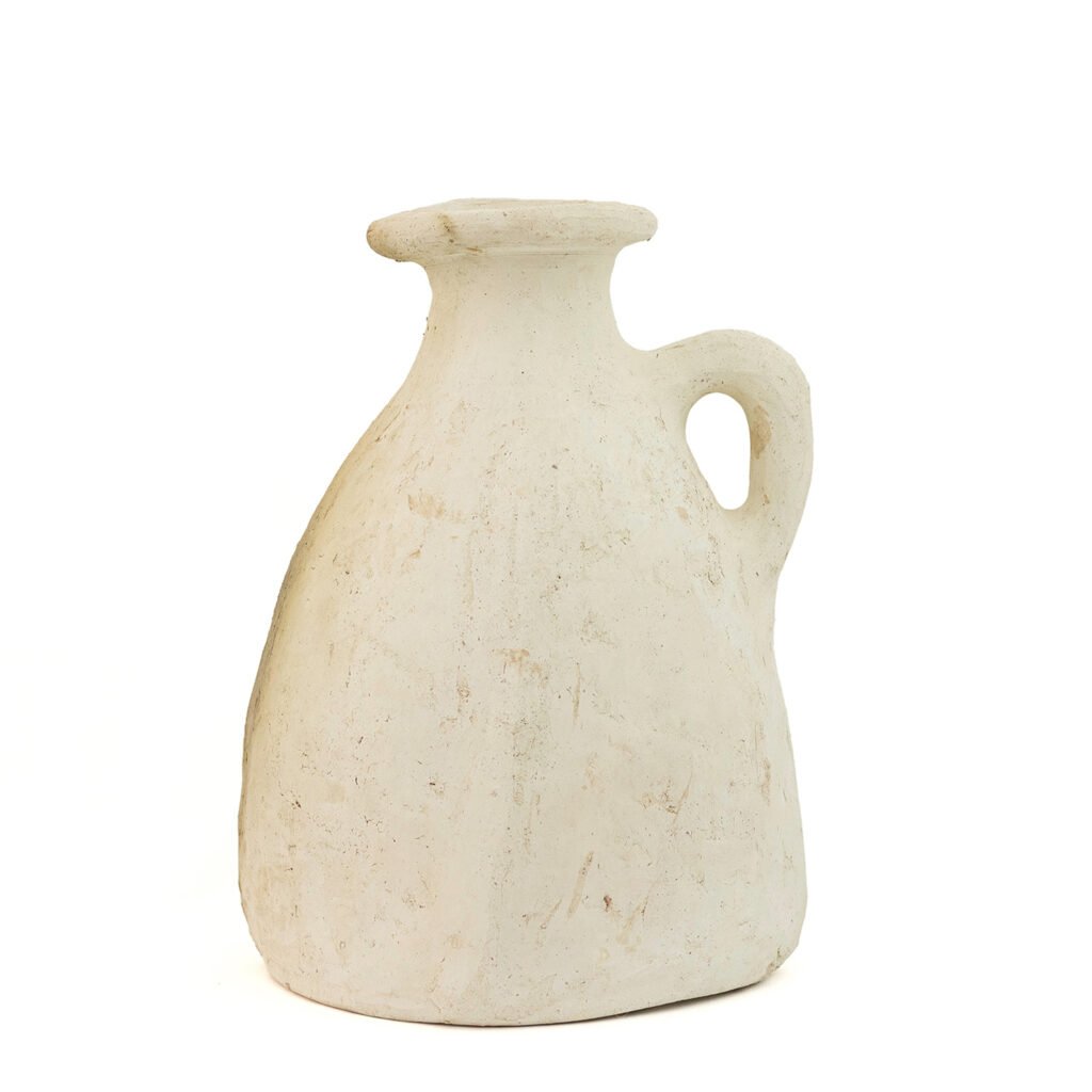 A white, rustic ceramic jug with a handle and a narrow neck, reminiscent of unglazed Tamegroute pottery, displays a slightly uneven surface.