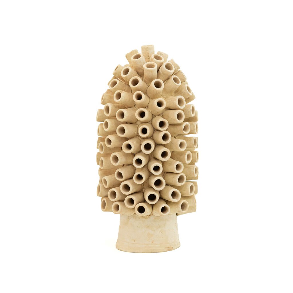An unglazed ceramic sculpture with cylindrical protrusions, echoing the earthy charm of Tamegroute pottery, forms a conical shape reminiscent of an abstract sea creature.