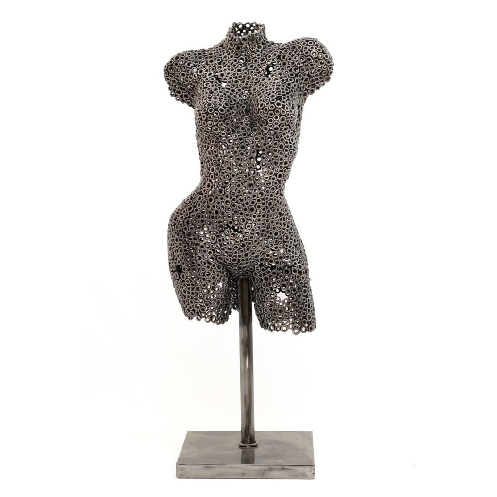 A captivating metal sculpture of a torso crafted from interconnected circular components, elegantly perched on a minimalist rectangular stand.