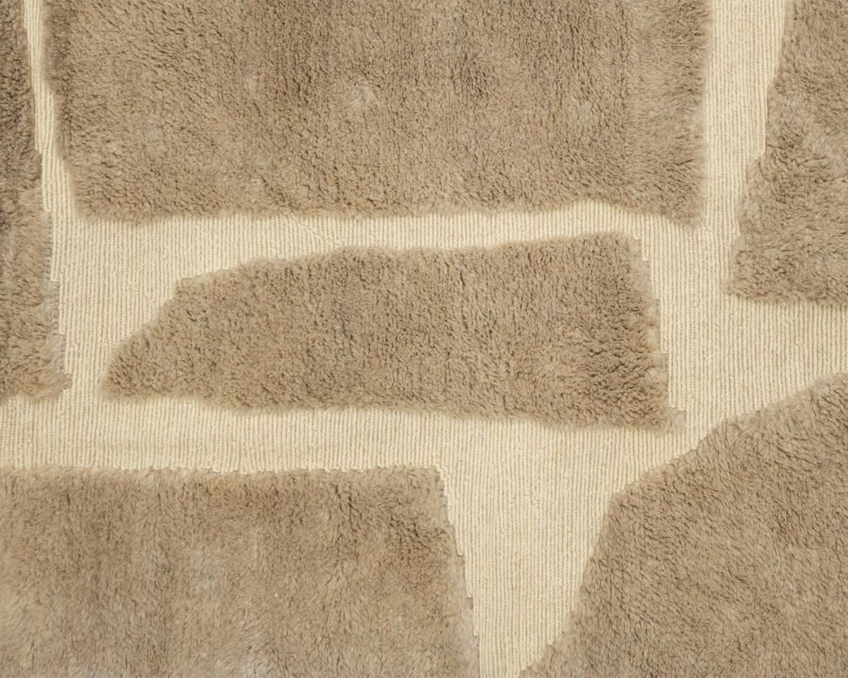 Close-up of a textured surface resembling a giraffe pattern, featuring irregular light brown shapes on a beige background, evoking the exquisite craftsmanship of handmade home decor.