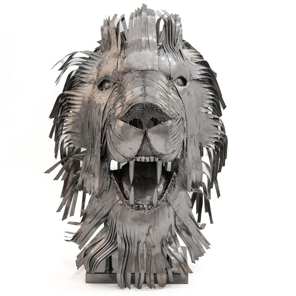 Steel sculpture of a lions head with a mane made of metal strips, featuring an open mouth and fierce expression.