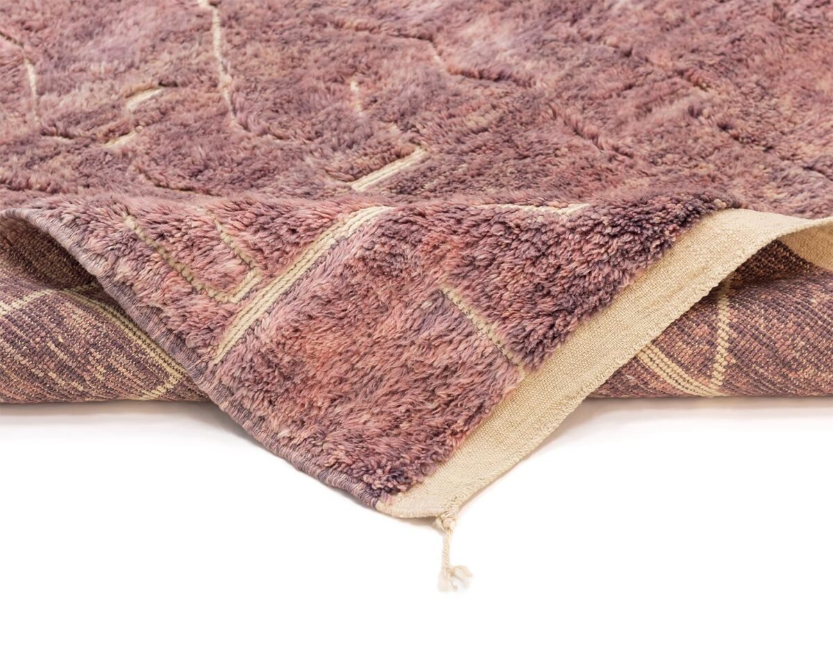 Close-up of a hand-knotted brown and beige rug with a textured, shaggy surface and a geometric pattern.