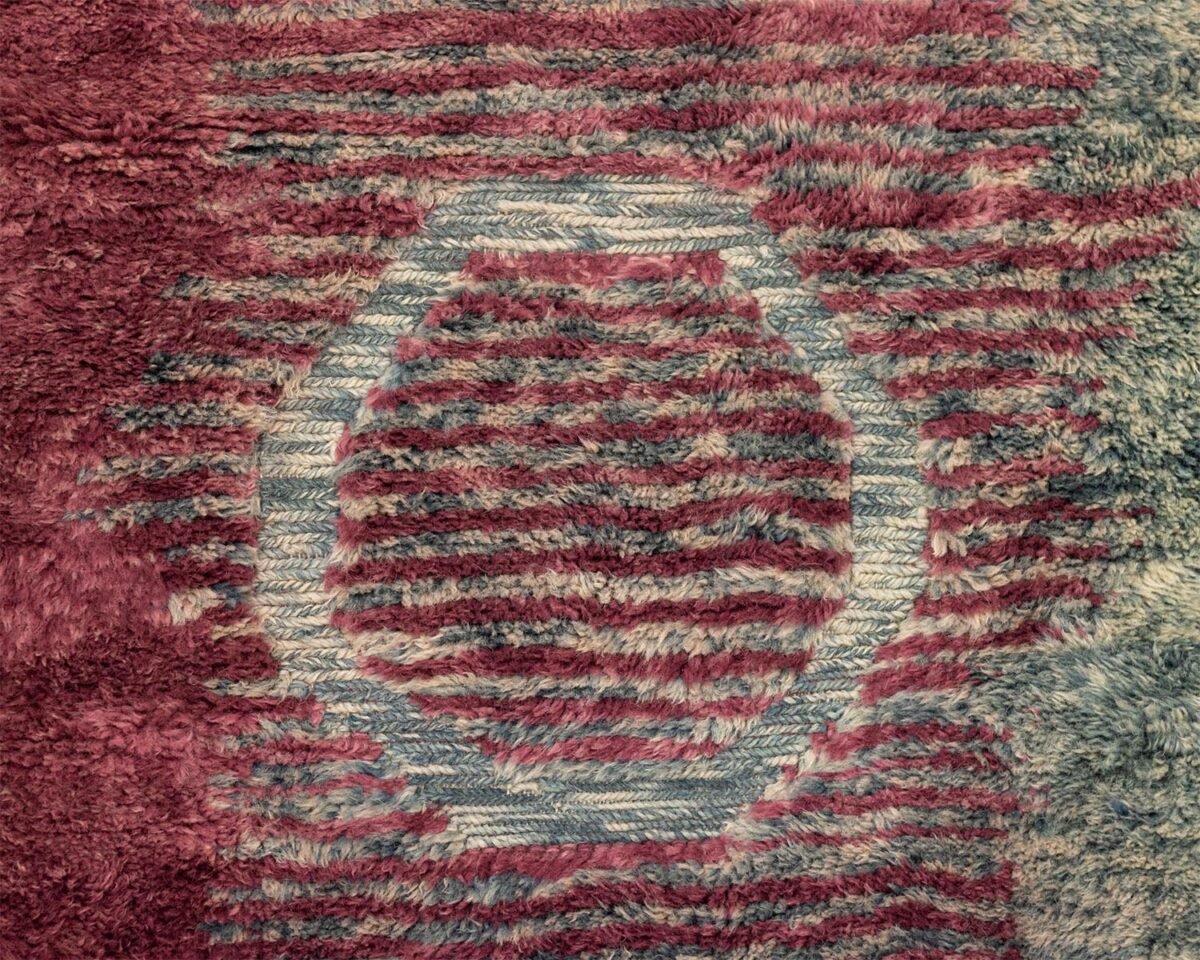 This luxury rug features a red and gray abstract pattern with a central circular design, beautifully surrounded by a textured striped background. Expertly hand-knotted, it adds an elegant touch to any space.