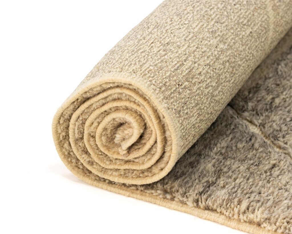 A rolled beige runner rug set against a white background, offering a neutral and elegant aesthetic.
