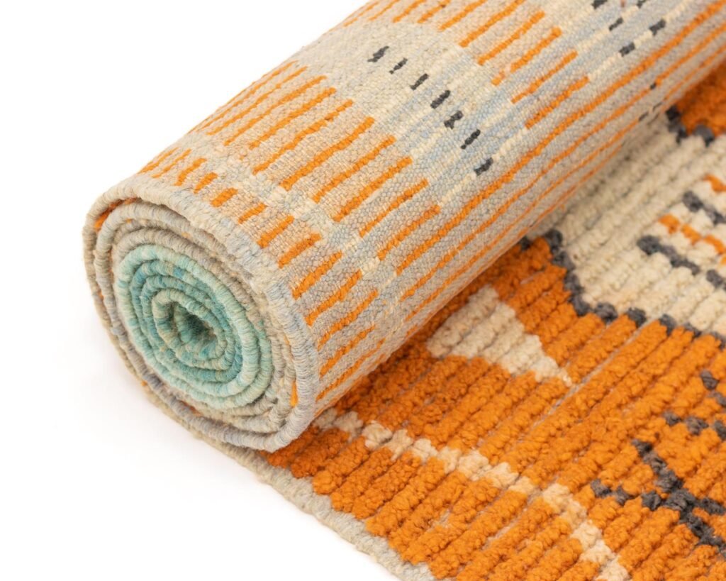 This Berber runner rug showcases an abstract pattern with vibrant orange, gray, and blue colors. Perfectly rolled up for easy transport, it adds a modern touch to any space while offering the classic charm of a traditional runner rug.