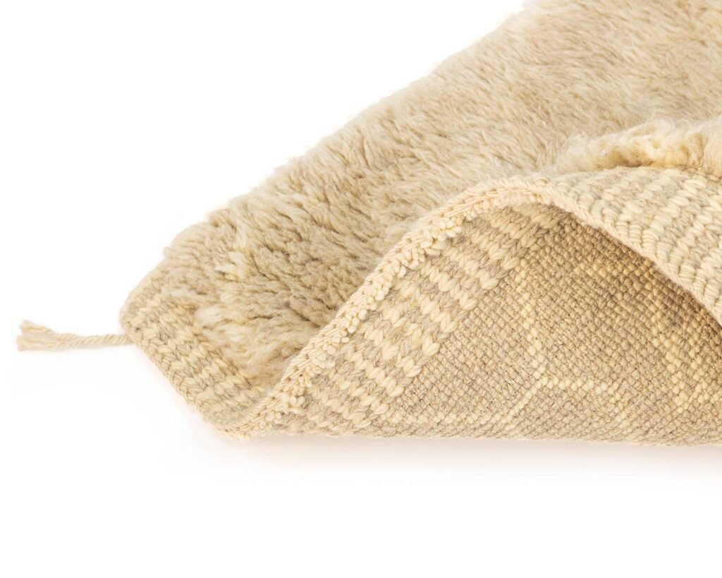 Close-up of a beige runner rug corner displaying the woven pattern on the underside and the fluffy texture on top.
