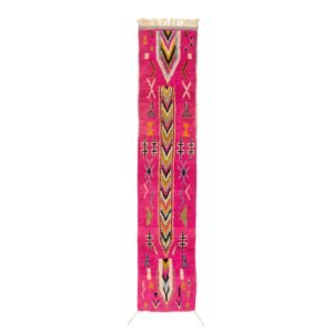 A narrow, colorful runner rug with a bold geometric pattern featuring pink, orange, and yellow hues, complete with fringe at both ends.