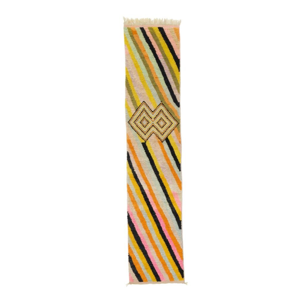 This vibrant rectangular textile showcases multicolored diagonal stripes complemented by a central geometric pattern, making it an eye-catching décor piece for any room.