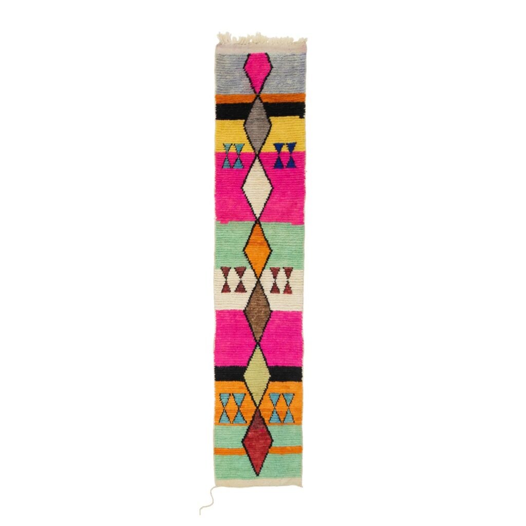 This vibrant, handwoven rug showcases geometric patterns with diamonds and triangles in pink, orange, teal, and black against a light background. Its perfect for adding a pop of color to any room.