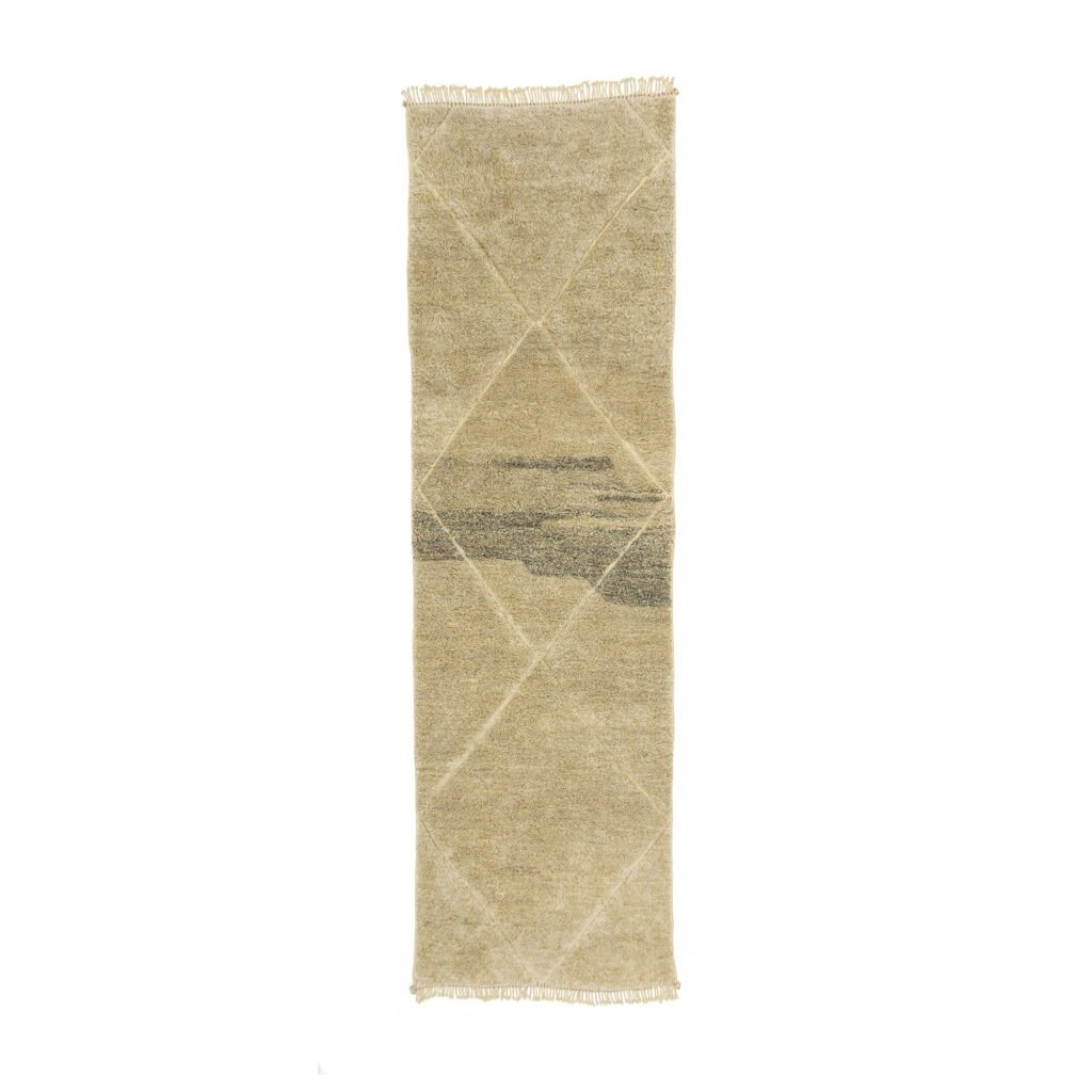 A long, rectangular beige runner rug with subtle diagonal lines and a central horizontal pattern in gray tones lies flat against a plain white background.