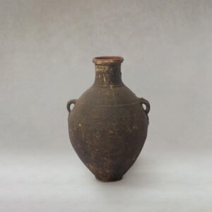 This ancient ceramic pot, with its two small side handles and narrow neck, showcases a rough, weathered surface that tells tales of bygone eras. Featuring intricate details, it brings a touch of history and artistry into any space.