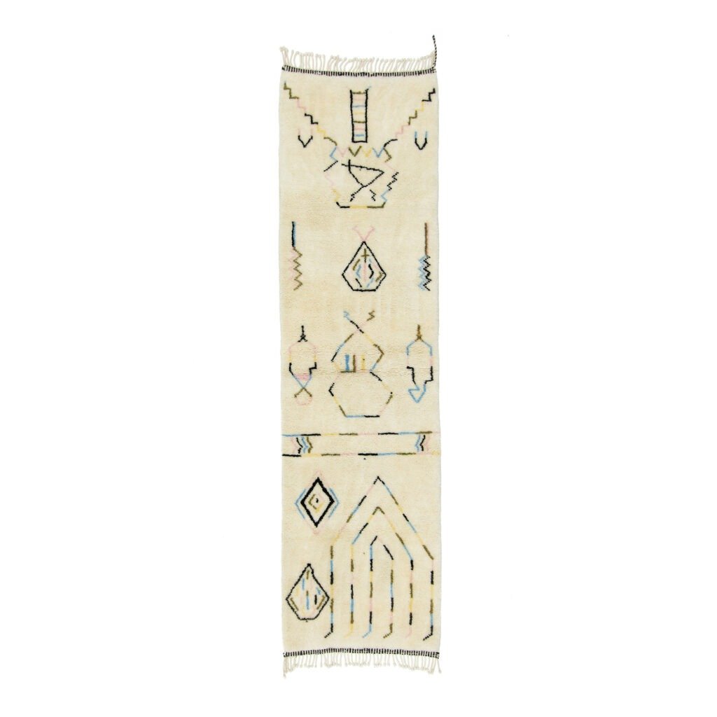 A beige rectangular rug with abstract geometric patterns in dark blue and light tan, featuring fringe on both ends, adds a touch of sophistication to any space. Its modern design stands out beautifully against a white background, creating an inviting atmosphere.