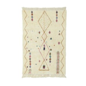 An artisanal rug in a rectangular beige design with fringed edges, showcasing hand-knotted geometric diamond patterns and vibrant details in pink, blue, and brown.