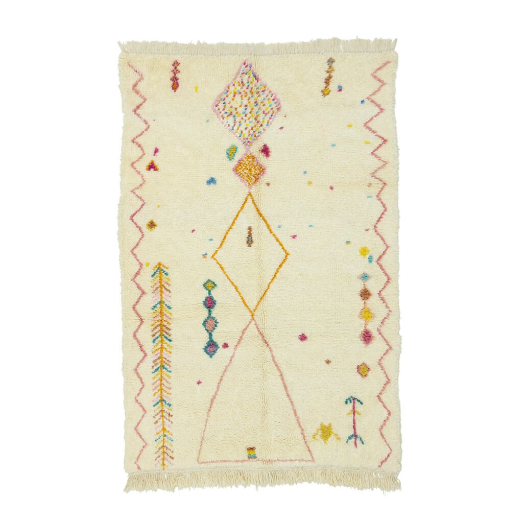 This luxurious, hand-knotted rectangular cream-colored rug features a mix of geometric patterns and colorful accents, including diamonds, zigzags, and small dots, with fringe adorning the shorter edges.