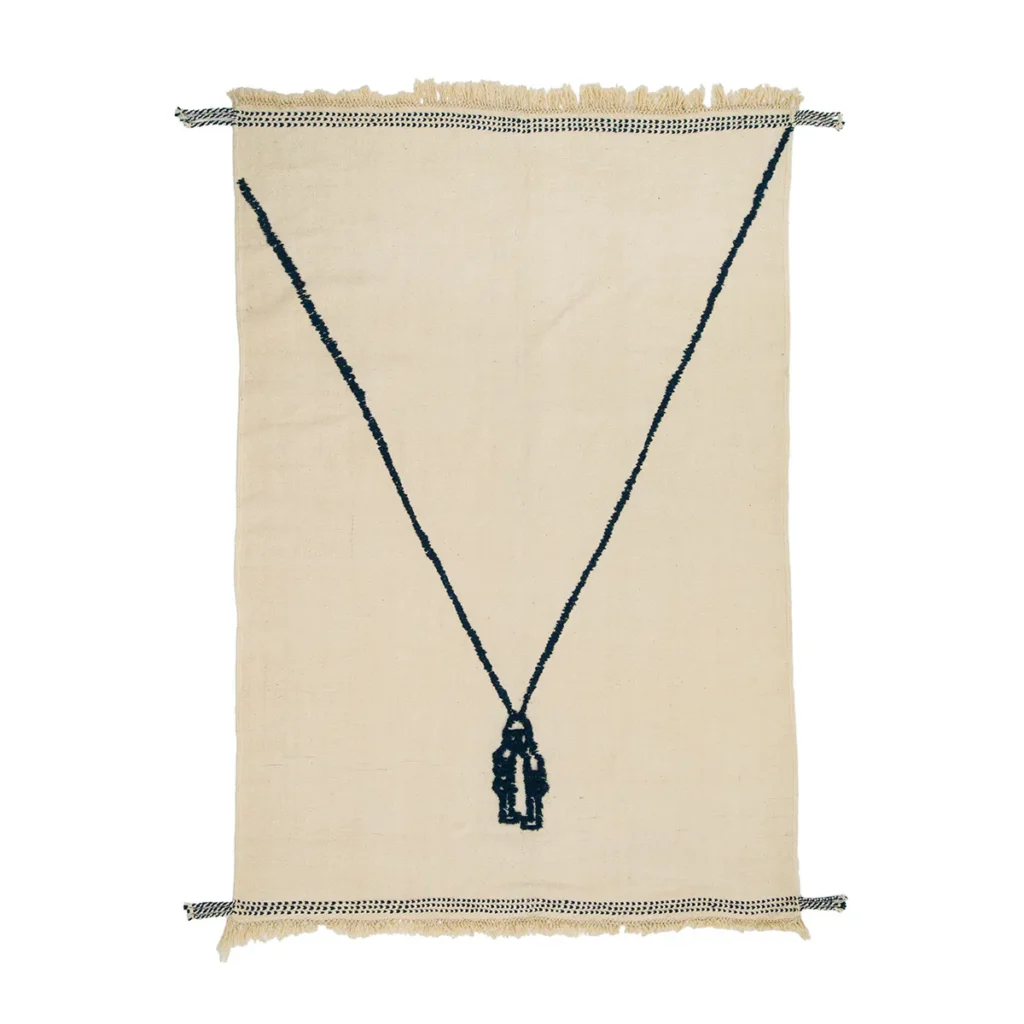 A beige handwoven textile with fringe edges features a striking black, Y-shaped beaded necklace design in the center.