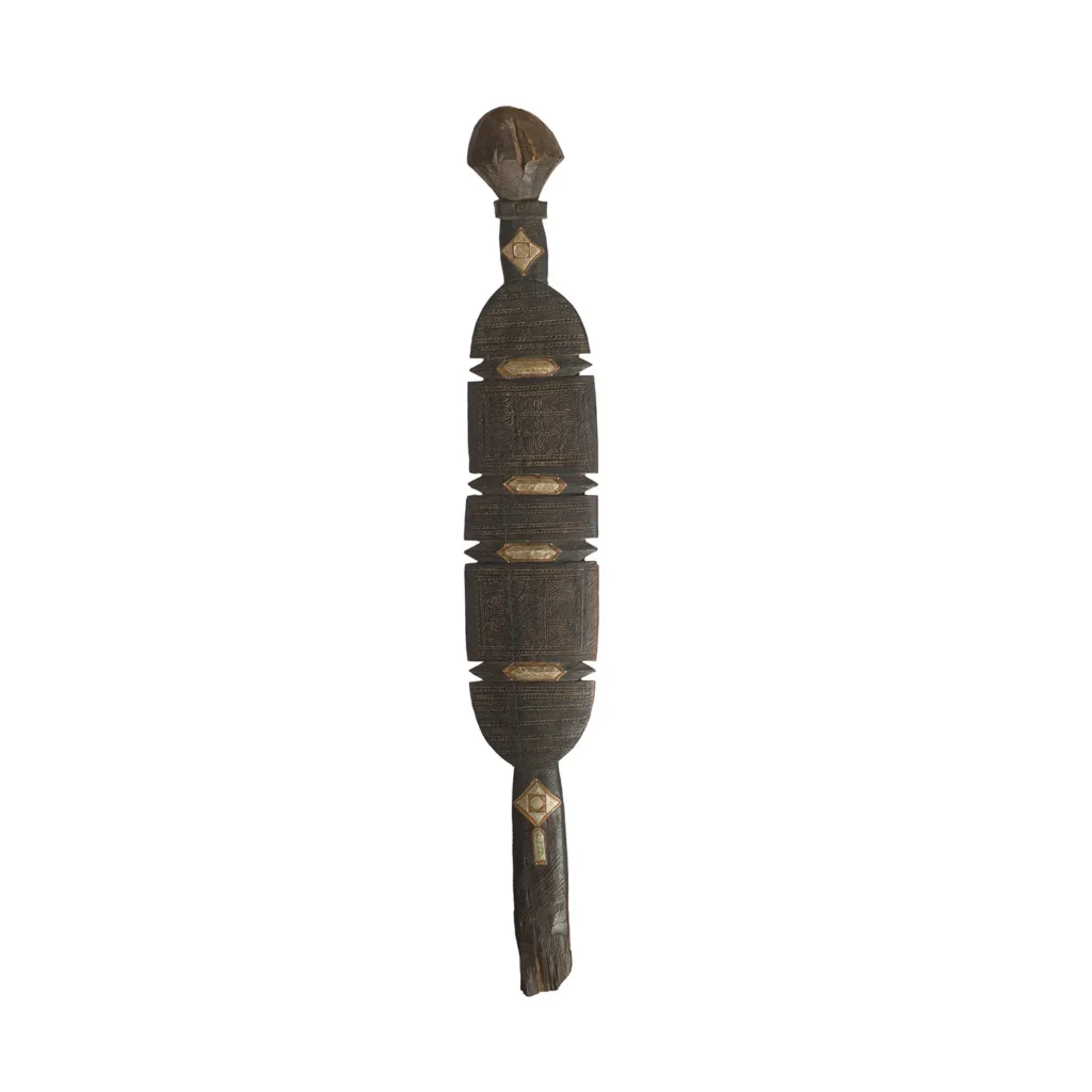 This hand-carved, vintage wooden piece boasts a cylindrical shape adorned with intricate geometric patterns and a rounded top, reminiscent of an artisanal tent peg from eras past.