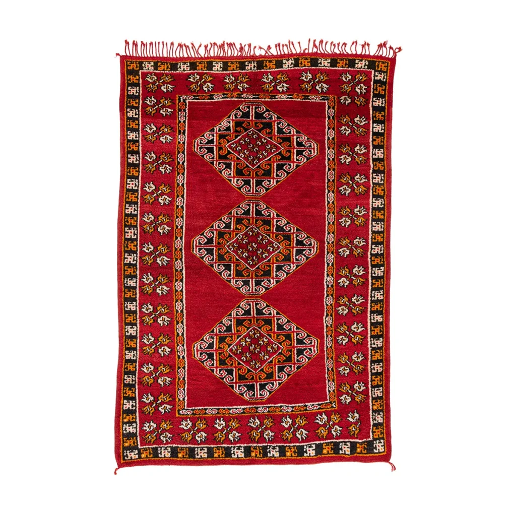 A vibrant red and black patterned rug featuring intricate geometric designs and an elegant decorative border, perfect for adding a touch of sophistication to any room.