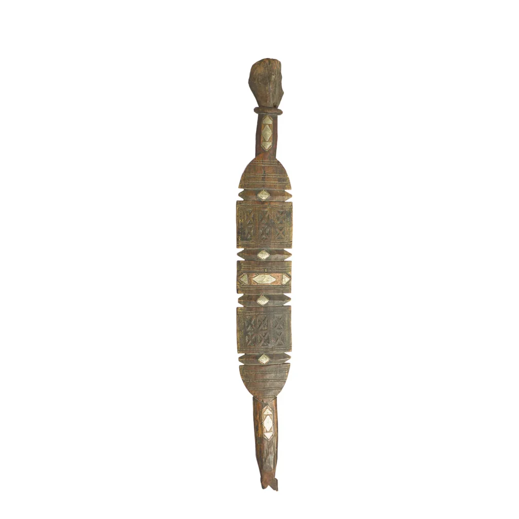 A carved wooden object with geometric patterns and earth tones, reminiscent of vintage wooden tent pegs, featuring symmetrical designs and a slightly rough texture.