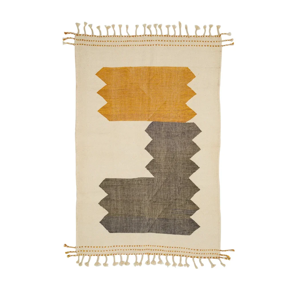 Rectangular woven rug with fringe edges, showcasing geometric patterns in mustard yellow and dark gray on a beige background, adds a touch of elegance to any rooms decor.