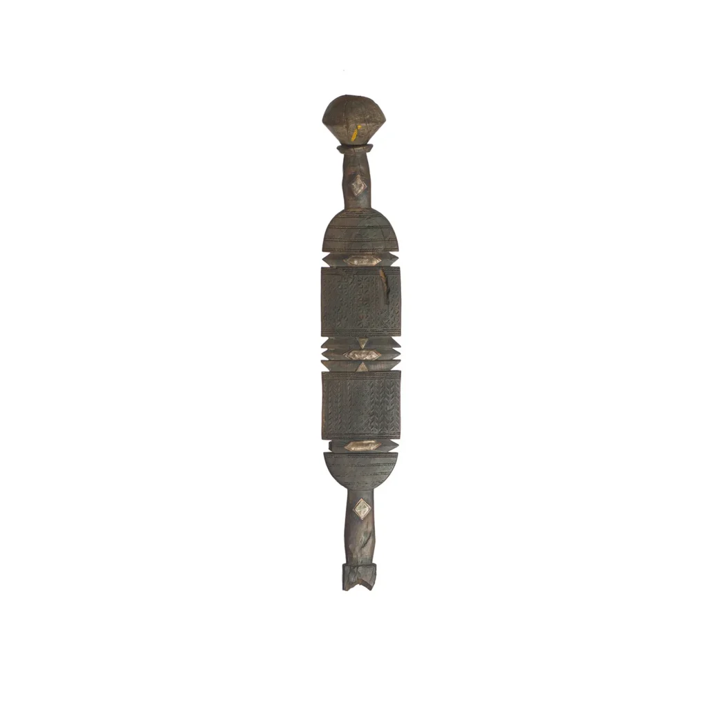 A hand-carved vintage wooden object with geometric patterns and a symmetrical design, reminiscent of an ornate tent peg, featuring bulbous ends and a central rectangular element.