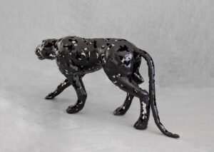 A striking panther metalwork sculpture with a glossy speckled texture stands on all fours against a plain gray background.