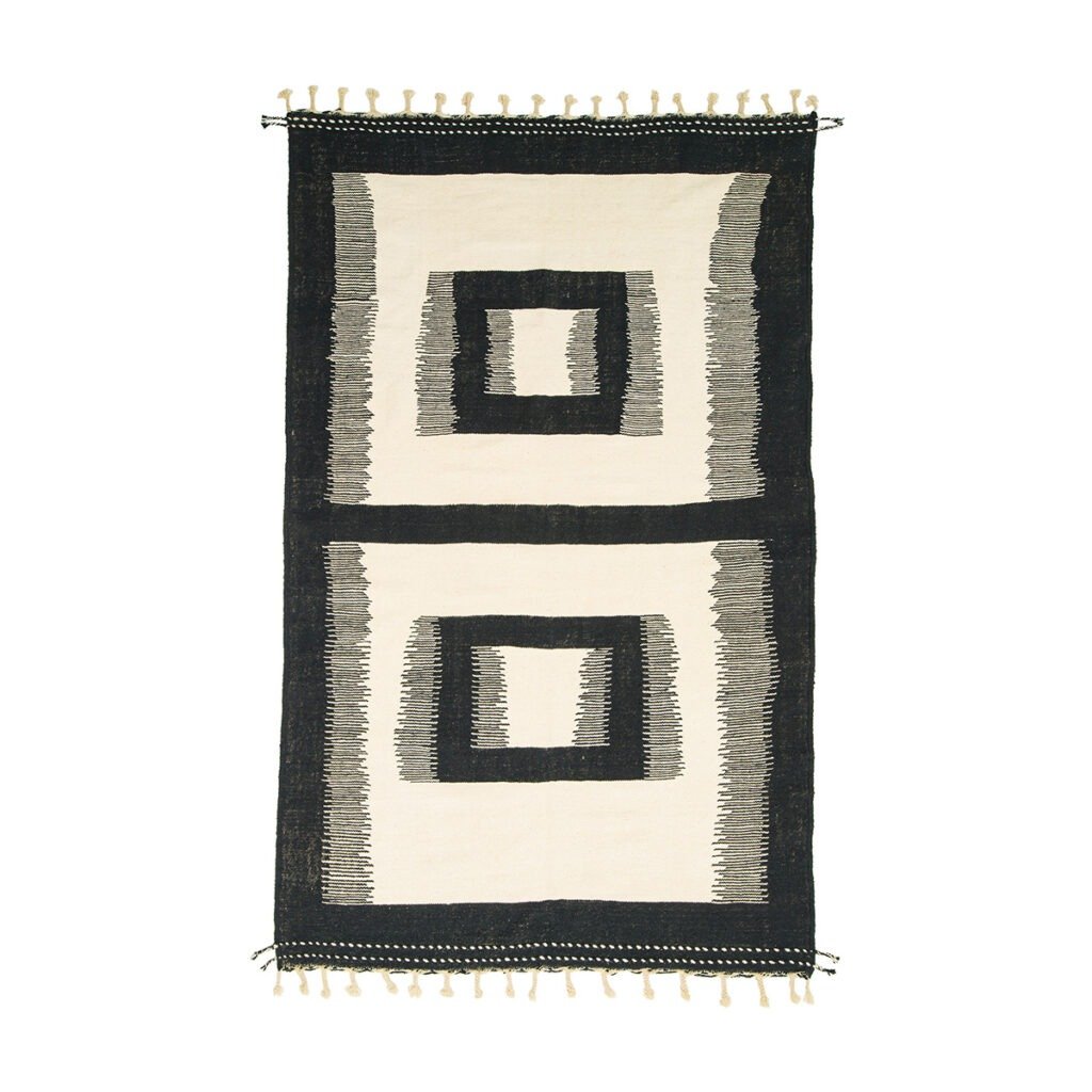 A rectangular rug features two black-bordered square patterns on a beige background, complemented by fringes on the shorter sides.