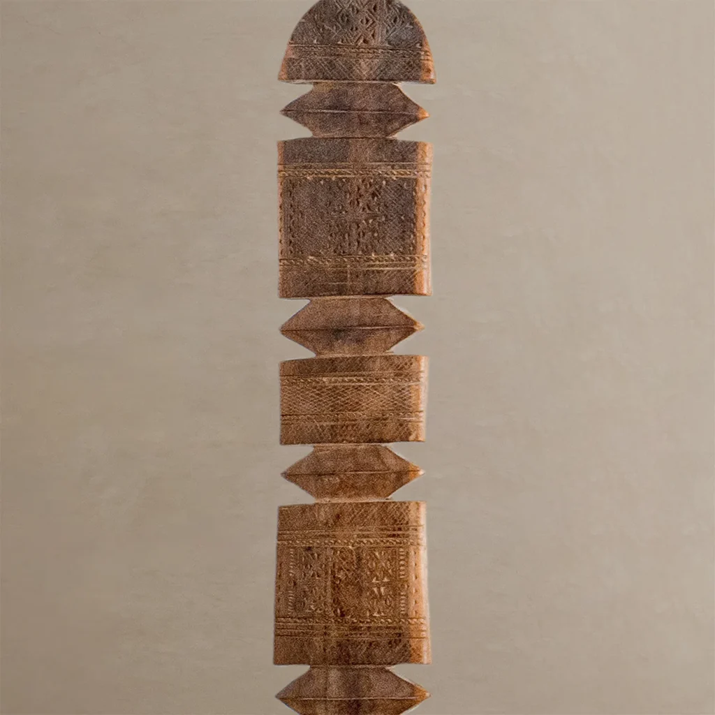 Hand-carved vintage ceremonial staff with intricate patterns, featuring a symmetrical design of geometric shapes stacked vertically, reminiscent of the artistry found in traditional wooden tent pegs.