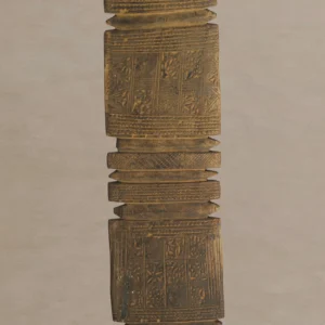 A hand-carved vintage wooden tent peg, showcasing intricate geometric patterns on a vertically aligned rectangular shape with ridges and decorative motifs on a plain background.