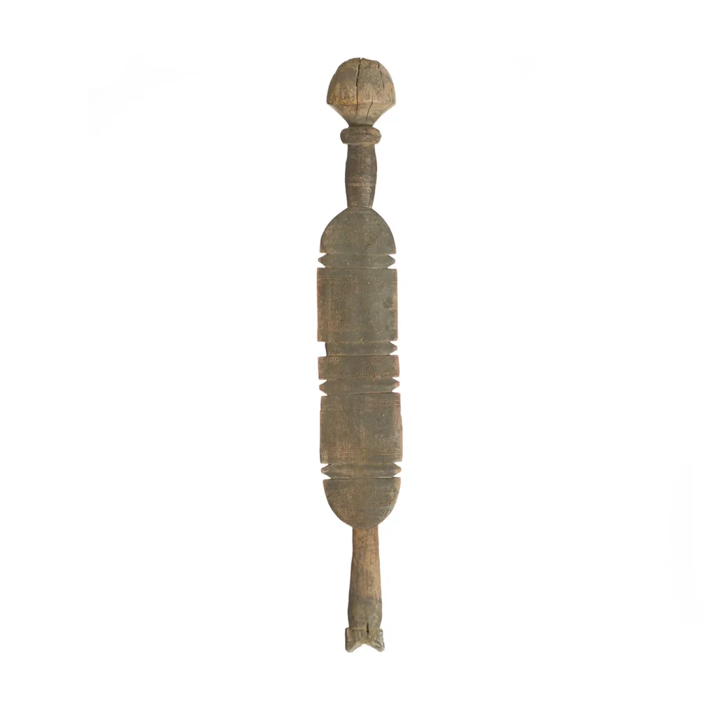 A hand-carved vintage wooden object exhibits a symmetrical shape with rounded ends and an intricate middle section, resembling an elegant tent peg, isolated on a white background.