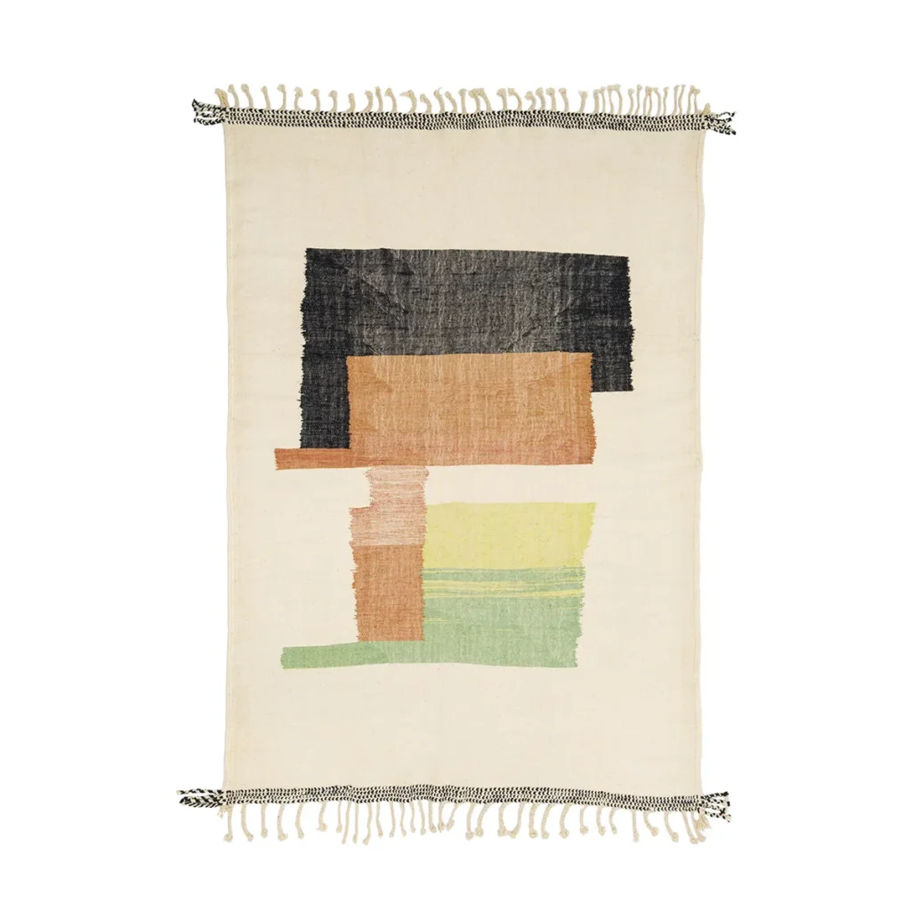 A rectangular woven rug with fringe edges showcases abstract colored blocks in black, brown, orange, and green on a beige background, adding a touch of artistic flair to any room.