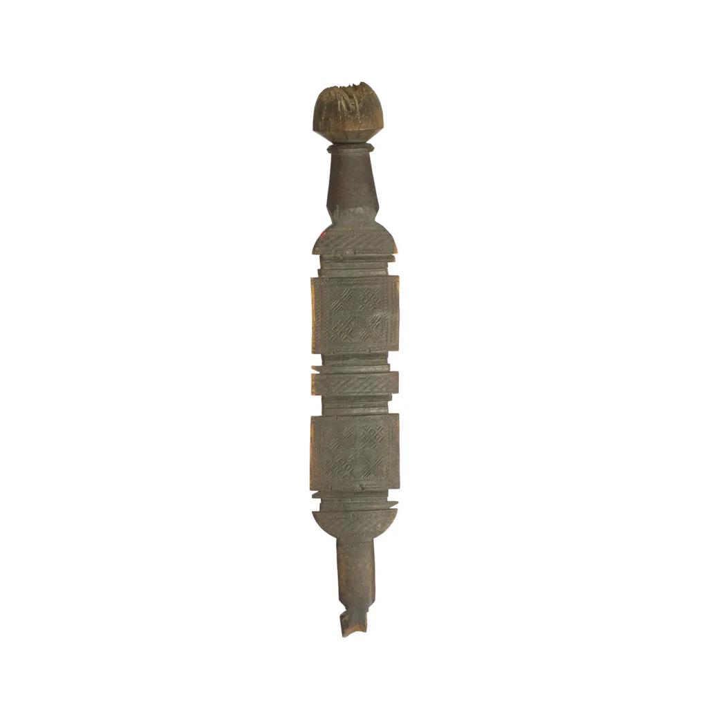 A hand-carved vintage wooden sculpture with intricate geometric patterns, reminiscent of an elongated tent peg with a rounded top.