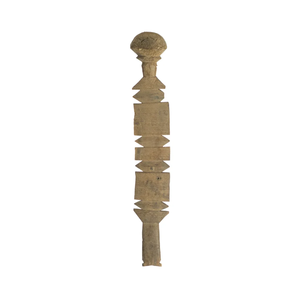 Hand-carved vintage staff with geometric shapes and a rounded top, echoing traditional African art, akin to the craftsmanship of a wooden tent peg.