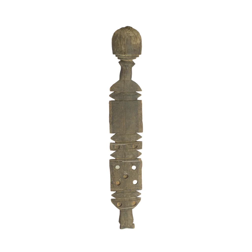 The carved wooden staff, reminiscent of vintage craftsmanship, is adorned with geometric shapes and small holes, topped with a rounded finish that echoes the elegance of antique tent pegs.