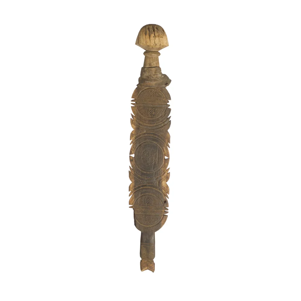 This hand-carved vintage wooden club boasts intricate circular and linear patterns, with a rounded top and tapered bottom, reminiscent of an elegant tent peg.