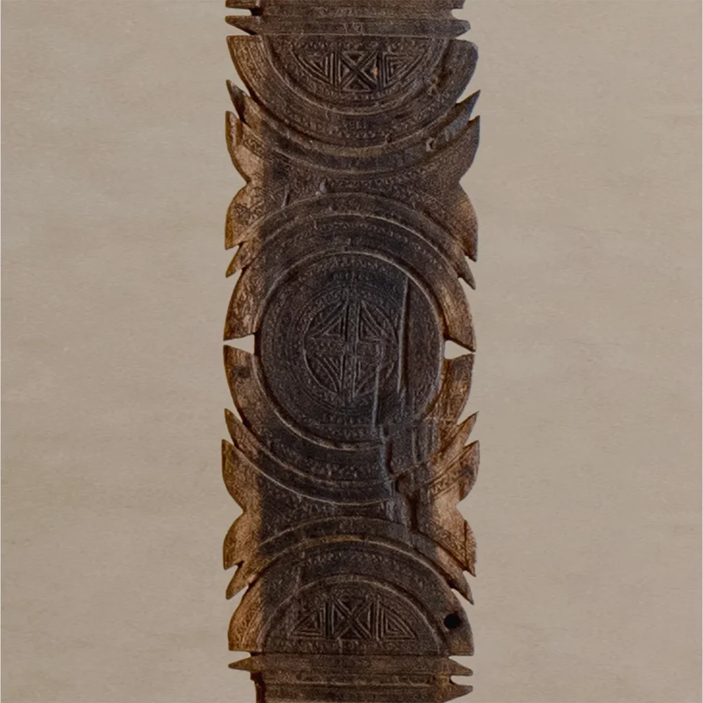Intricately hand-carved vintage wooden column adorned with circular and geometric designs, reminiscent of an artisans tent peg, set against a neutral background.