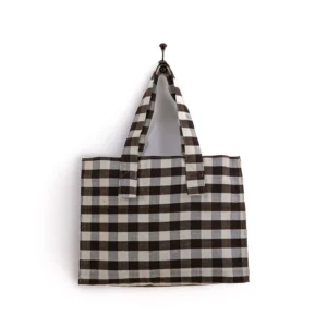 Brown and white checkered tote bag hanging on a wall hook.