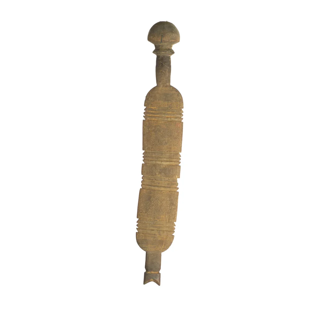 Hand-carved, this vintage wooden tent peg boasts an elongated shape adorned with intricate geometric patterns and notches. Its surfaces narrate a story of time, with wear marking its history.