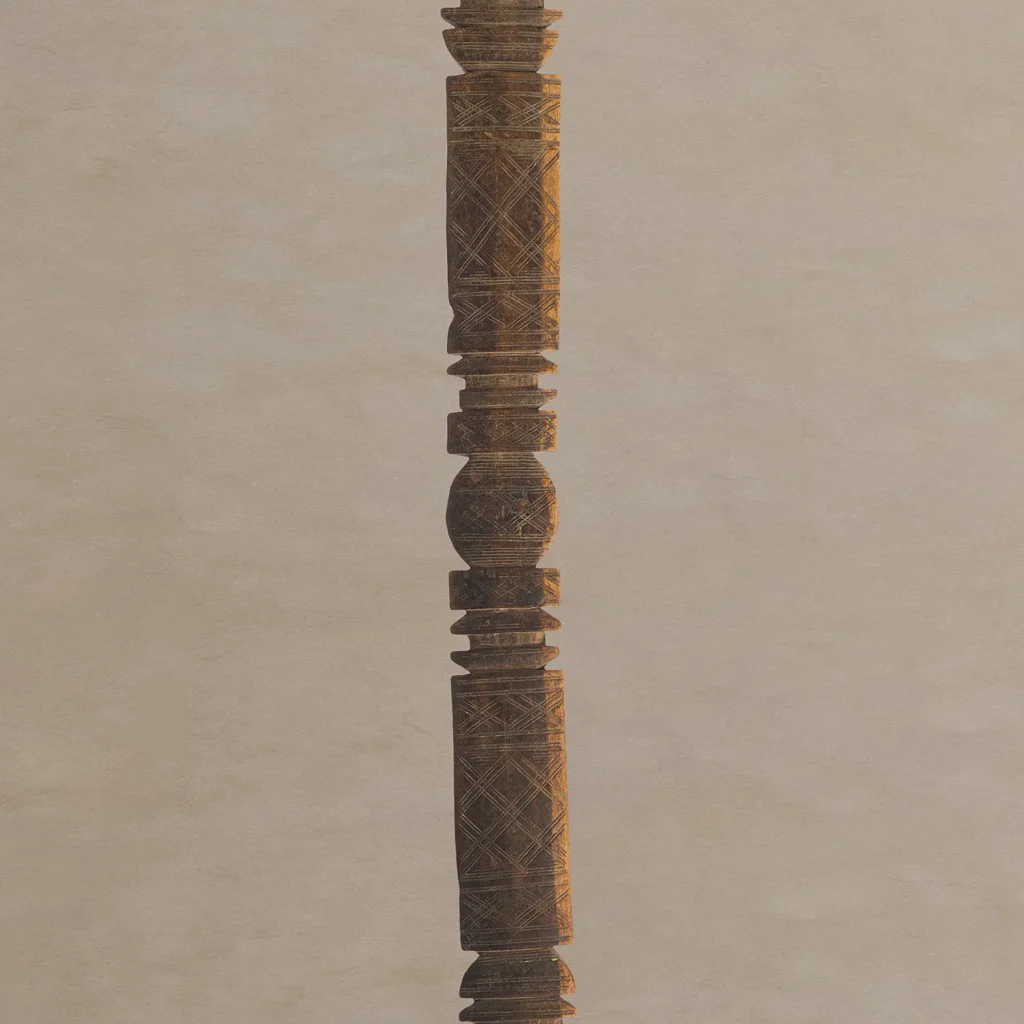 A hand-carved vintage wooden spindle with intricate carvings stands vertically against a plain background, reminiscent of an antique tent peg in its timeless elegance.
