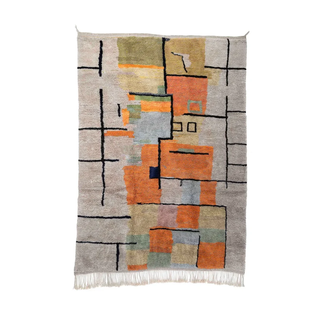 This hand-knotted, geometric-patterned tapestry showcases intersecting black lines with blocks of orange, green, and blue set against a beige background. Fringes adorn the bottom edge, enhancing its artisanal charm.