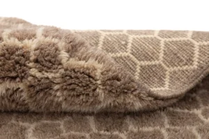 A close-up of a folded brown and beige wool creation with a geometric pattern, revealing its textured and plush surface. This hand-knotted piece exudes the quality and craftsmanship of authentic Moroccan rugs.