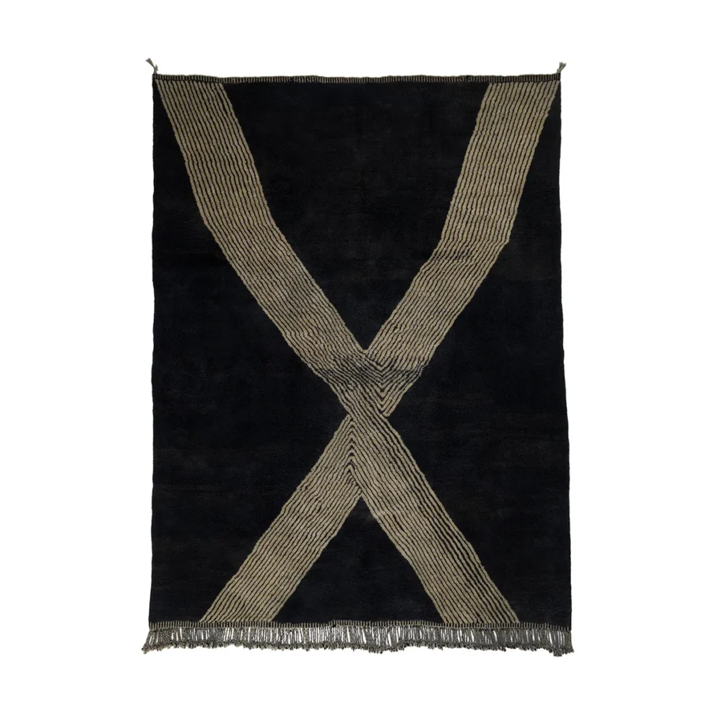 This hand-knotted rug boasts a striking design with two intersecting beige lines forming an X pattern on a black background, complete with fringed edges. A true example of artisanal craftsmanship reminiscent of authentic Moroccan rugs.