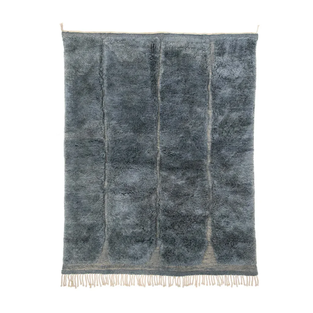 This hand-knotted, dark gray fuzzy rug features a textured design with visible seams and short fringe on the bottom edge, highlighting the artisanship reminiscent of authentic Moroccan rugs.