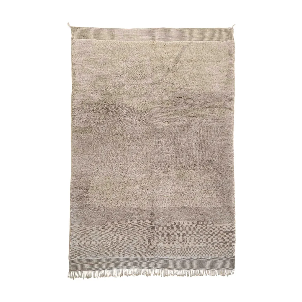 Experience the elegance of a hand-knotted Moroccan rug, featuring a textured beige and brown design with subtle patterns. The luxurious piece is finished with tassels on its white-fringed edges, creating an inviting focal point for your space.