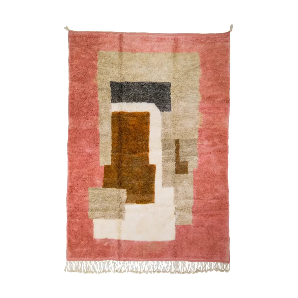 This luxury rug is a hand-knotted masterpiece, showcasing a rectangular abstract design with geometric patterns in shades of pink, orange, beige, and brown. Elegant fringes adorn the bottom edge.
